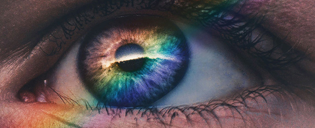 an eye with an iris which reflects a rainbow